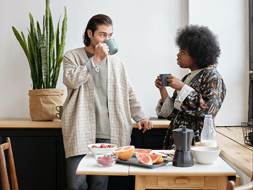 A man and a woman drinking coffee in a kitchen icon