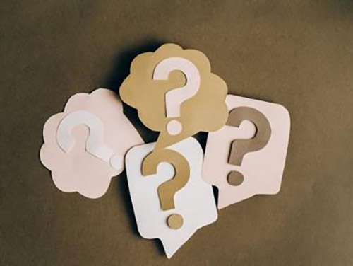 Pieces of paper cut out in different shaped thought bubbles with question marks in them icon