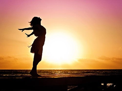 A person stretching in front of a large sunrise icon