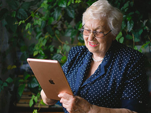 An older woman looking at an iPad icon