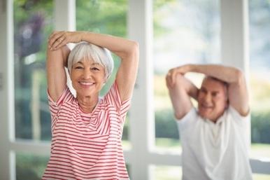 An older couple doing a tricep stretch together icon