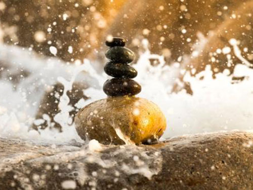 A pile of zen rocks with water crashing around them icon